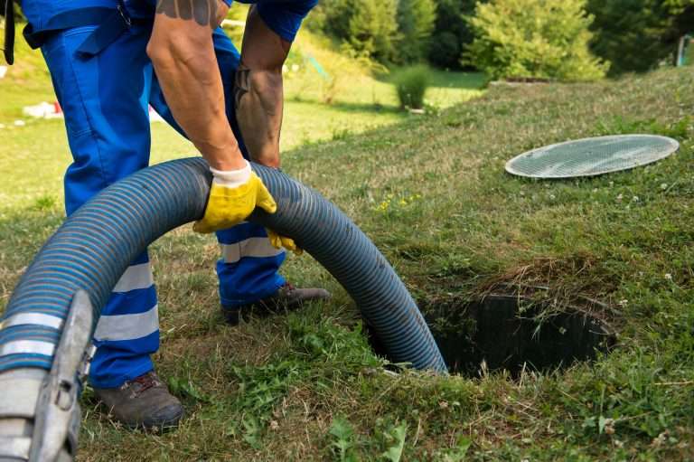 plumber performing septic tank pumping western rooter