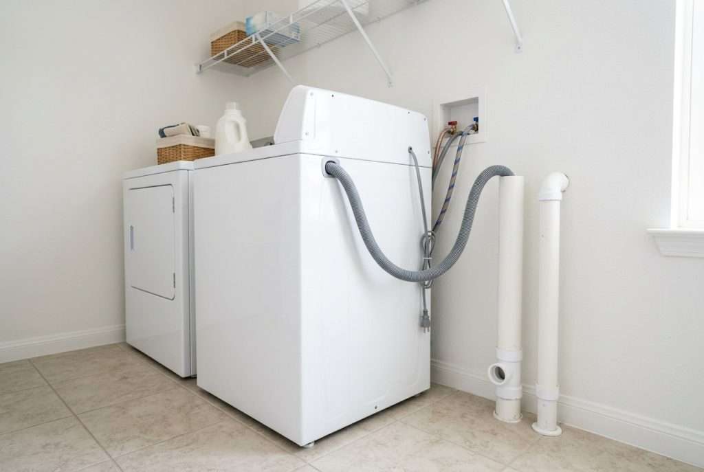 Washing machine drain hose connected to standpipe in laundry room