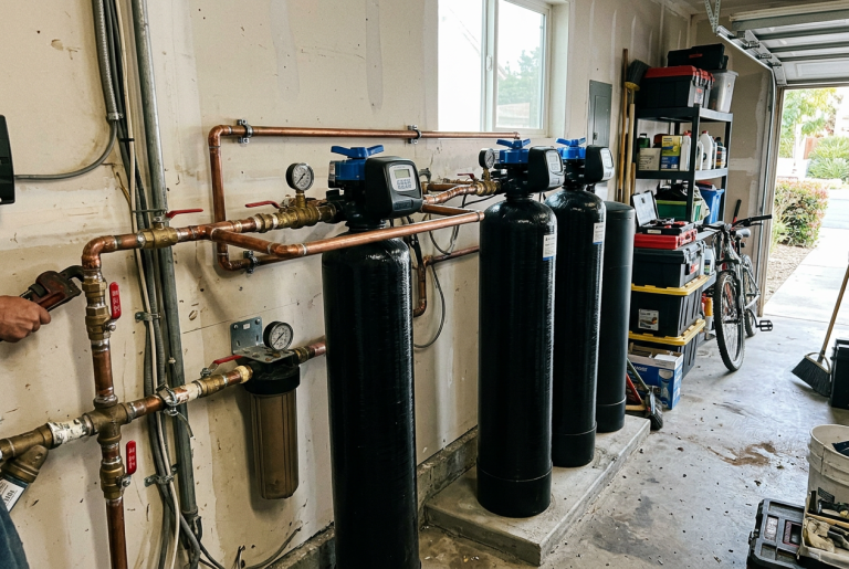 Whole house water filtration system with multiple filter tanks installed in a garage