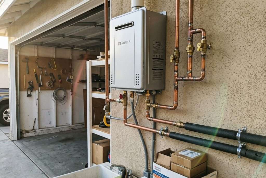 Tankless water heater mounted on wall with copper pipe fittings
