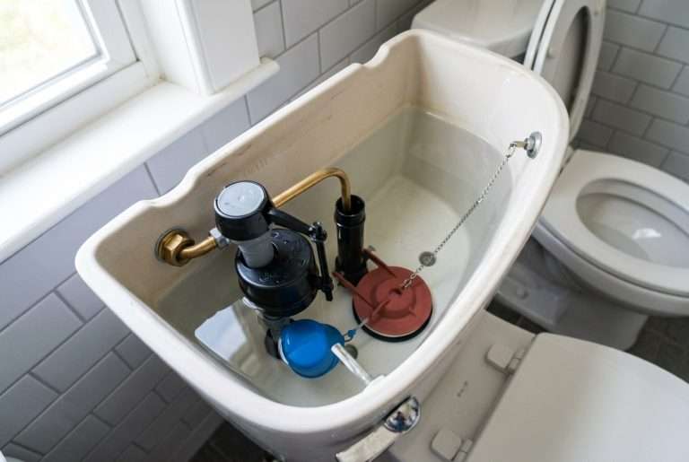 Open toilet tank showing fill valve and flapper assembly